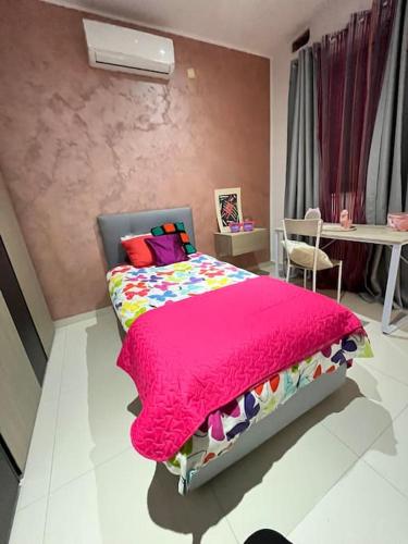 Duplex Maisonette with roof في Fgura: غرفة نوم بسرير وبطانية وردية