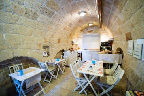 a kitchen with tables and chairs in a stone wall at B&B Casa Dorsi in Polignano a Mare