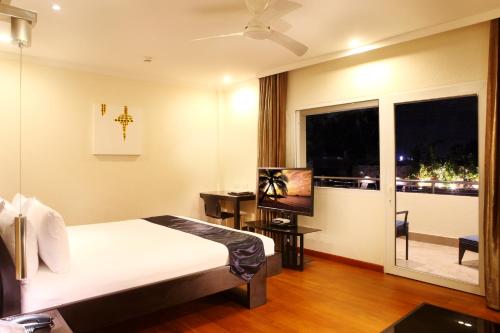 a hotel room with a bed and a window at Queens Hotel Angeles City in Angeles