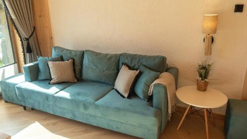 a blue couch in a living room with a table at Apartamenty Osada Biała Woda Szczawnica Jaworki in Szczawnica