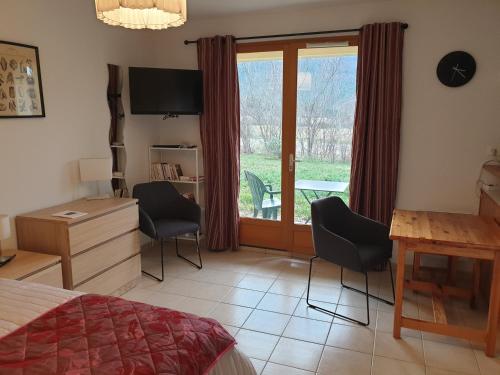 une chambre avec un lit, un bureau et une fenêtre dans l'établissement Studio Montbrun les bains, à Montbrun-les-Bains
