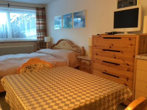 een slaapkamer met 2 bedden en een dressoir met een tv bij Double room with a kitchenette in a beautiful surrounding in Sautens