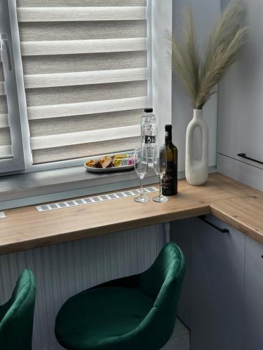a kitchen with two green chairs and a table with wine glasses at FANTASY ROOM in Iaşi