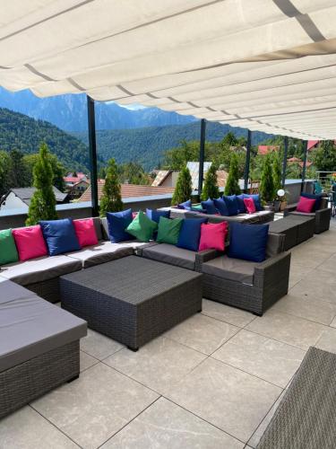 a patio with couches and pillows on a roof at HOTEL CARPAT INN in Azuga