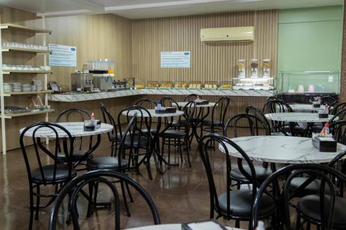 una sala da pranzo con tavoli e sedie in un ristorante di Hotel Lawrence a Foz do Iguaçu