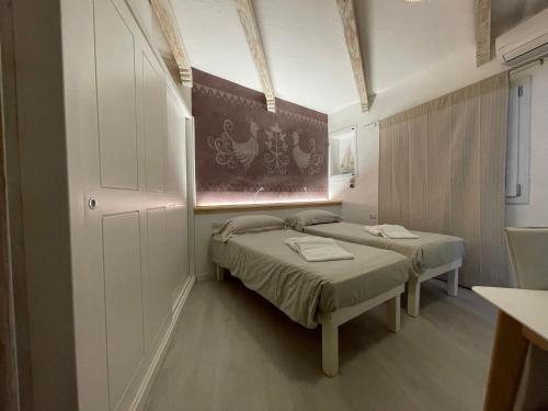 two beds in a small room with a window at Domus de Diana in Olbia