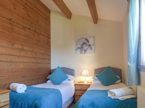 sypialnia z 2 łóżkami i niebieskimi poduszkami w obiekcie Lodge 3 w mieście Kinlet