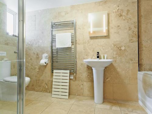 a bathroom with a sink and a toilet and a shower at Manor House in Crantock