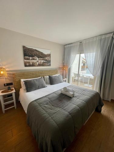ein Schlafzimmer mit einem Bett, auf dem ein Stofftier liegt in der Unterkunft Hostal Sa Tuna in Begur