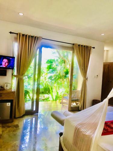 Un dormitorio con una cama y una puerta corrediza de vidrio. en Kailash Bali, en Ubud