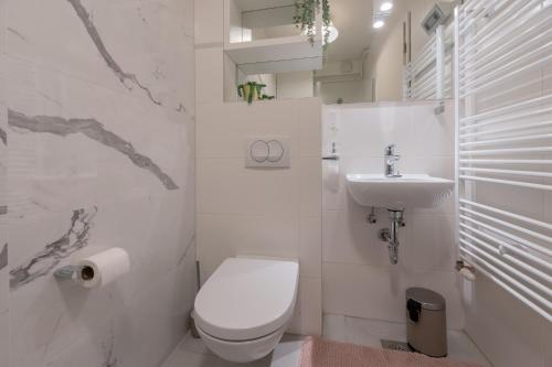 een witte badkamer met een toilet en een wastafel bij Liberty in Zagreb