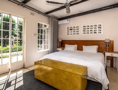 Un dormitorio con una cama grande con un banco de oro al final. en Graskop Hotel en Graskop