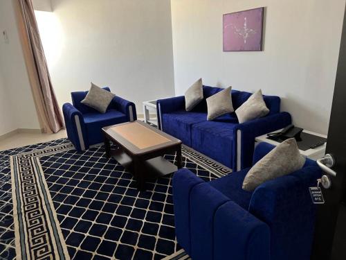 ein Wohnzimmer mit blauen Sofas und einem Tisch in der Unterkunft HOTEL NAKHIL in Nouadhibou