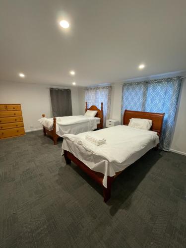 a hotel room with two beds and a dresser at LCF Rosehill Accommodation 3 free car parking inside property G2 in Sydney