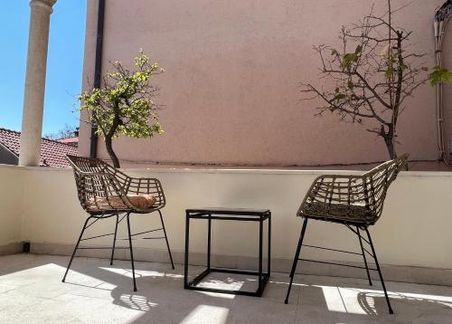 two chairs and a table in front of a wall at boutique Villa Dorma in Dubrovnik