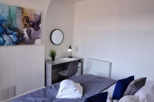 a bedroom with a bed and a desk with a mirror at Bury Stays in Bury