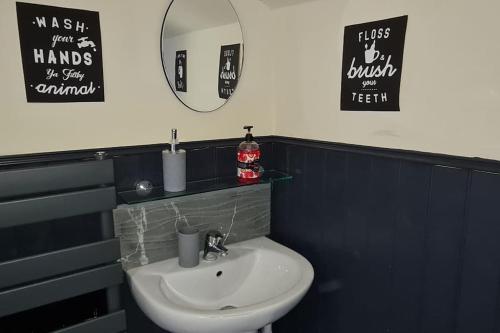 a bathroom with a white sink and a mirror at Bury Stays in Bury