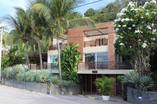a building with palm trees in front of it at Casa Surucuá com localização espetacular frente à Praia do Centro de Pipa - 2 a 4 quartos suite in Pipa