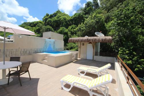 a patio with a table and chairs and a swimming pool at Casa Surucuá com localização espetacular frente à Praia do Centro de Pipa - 2 a 4 quartos suite in Pipa