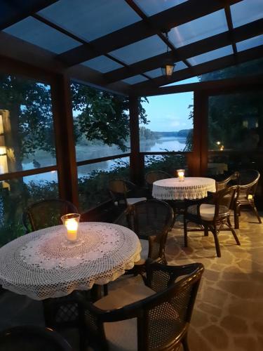 a restaurant with two tables and chairs with candles at Dwór w Zabużu in Zabuże