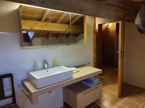 une salle de bain avec un lavabo blanc et un miroir dans l'établissement Mas avec piscine, à La Bastide-dʼEngras