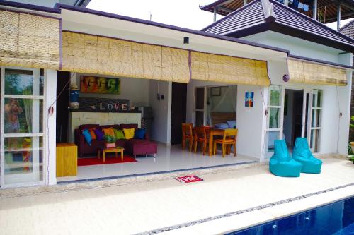 a house with a pool in front of it at Ratna Villa in Ubud