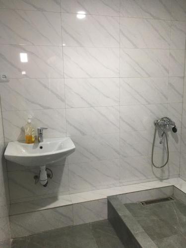 y baño blanco con lavabo y ducha. en Friendly B&B, en Gyumri