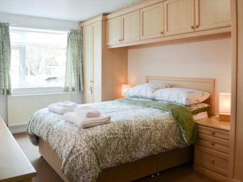 a bedroom with a bed with towels on it at The Cottage in Bridlington