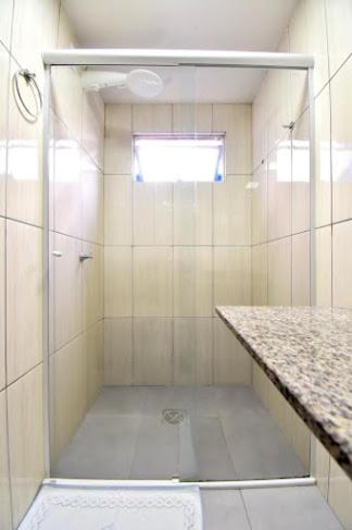 a shower with a glass door in a bathroom at Hotel Lawrence in Foz do Iguaçu