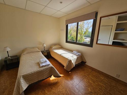 查克拉斯德科里亞的住宿－DEPTO EN CHACRAS DE CORiA，一间卧室设有两张床和窗户。