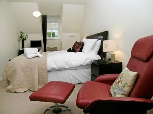 ワークワースにあるウォーターサイドのベッドルーム1室(ベッド1台、赤い椅子付)