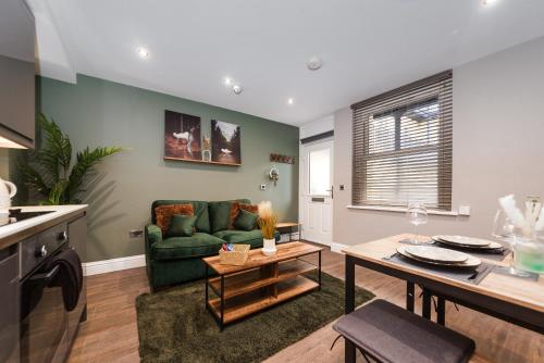 a living room with a green couch and a table at Modern Apartment in Brighton City centre in Brighton & Hove