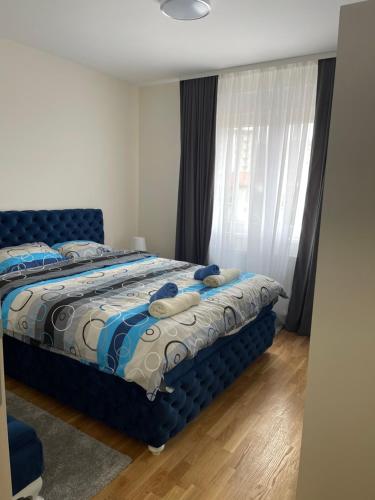 a bedroom with a blue bed with pillows on it at Cvetanov trg LUX 1 in Belgrade