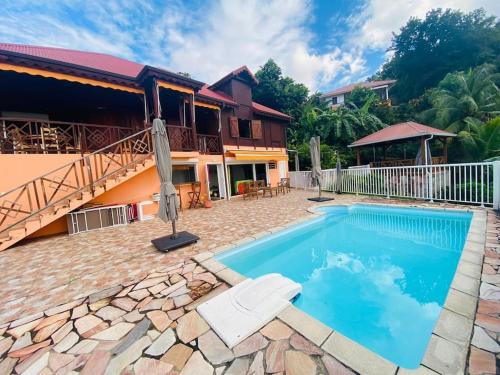 une villa avec une piscine et une maison dans l'établissement Villa au soleil couchant avec vue mer piscine sel, à Bouillante