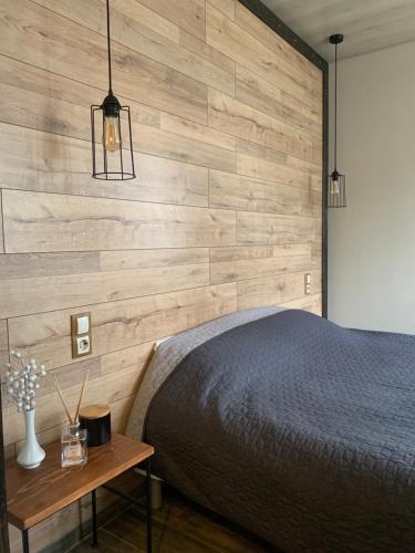 a bedroom with a bed and a wooden wall at Vorzel house in Vorzelʼ