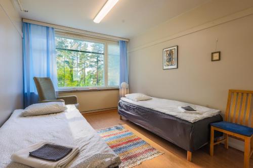 una camera con due letti e una sedia e una finestra di Vinsanvilla Bed and Breakfast a Ruovesi