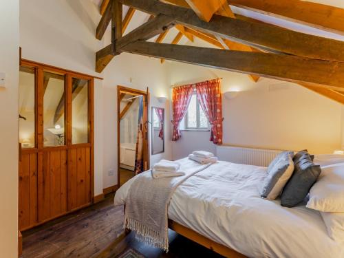 a bedroom with a large bed in a room with wooden floors at Pass the Keys The Stable in Norwich