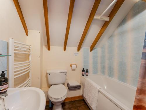 a bathroom with a toilet and a tub and a sink at Pass the Keys The Stable in Norwich