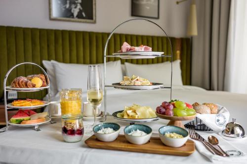 a tray of food on a bed with plates of food at Hotel Saski Krakow Curio Collection by Hilton in Kraków