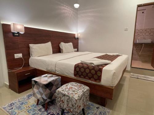 a bedroom with a large bed and a stool at Yellow Sky in Baga