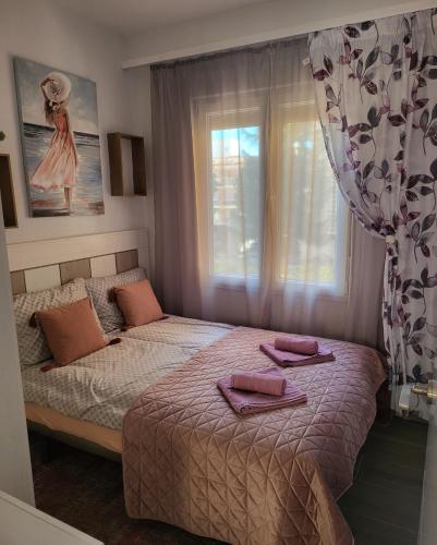 Un dormitorio con una cama con toallas rosas. en Emma Apartman, en Santa Pola