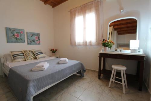 1 dormitorio con cama, escritorio y espejo en Villa Rouvis with outdoor Hot Tub, en Ligaridia