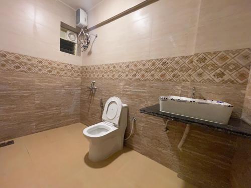 a bathroom with a toilet and a sink at Yellow Sky in Baga
