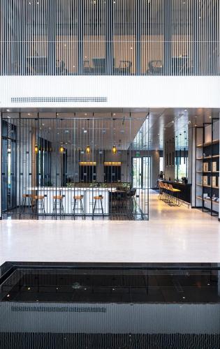 a lobby with tables and chairs in a building at Anya Hotel Quy Nhon in Quy Nhon