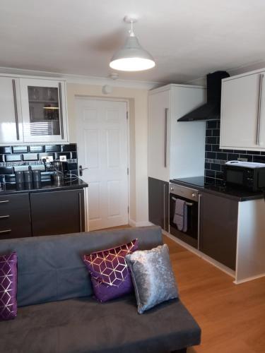 a living room with a couch and a kitchen at Victoria Quays Apartments, Fleetwood in Fleetwood