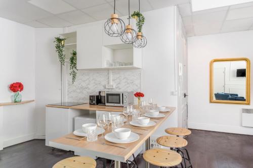 uma cozinha com uma mesa longa com cadeiras e um micro-ondas em Cosy 3 bedrooms apartment with bathrooms - Louvre em Paris