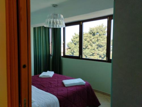 una camera con letto viola e finestra di franci e aurora house a Capo dʼOrlando