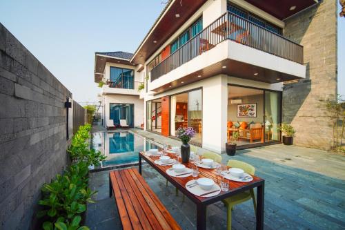 a patio with a table and chairs next to a house at Hola Villa 1 by Ovui in Hoi An