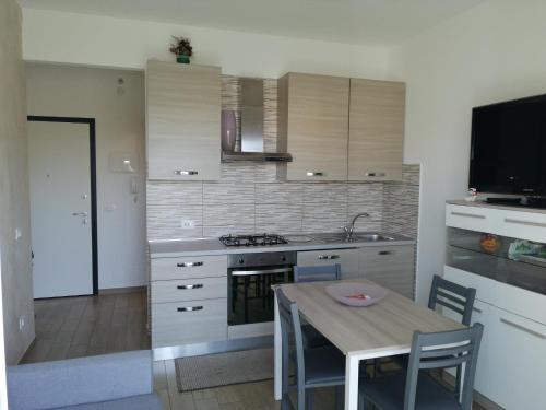 uma cozinha com uma mesa, um lavatório e um fogão em Casa Bonello 12 em Sanremo