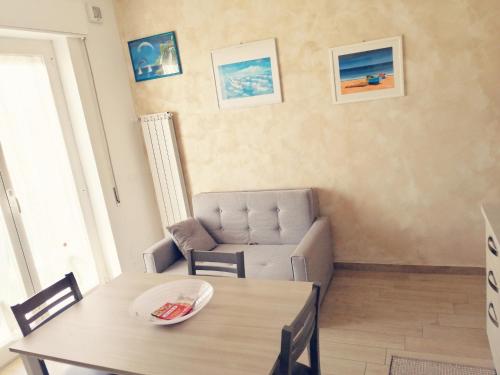 uma sala de estar com uma mesa e uma cadeira em Casa Bonello 12 em Sanremo